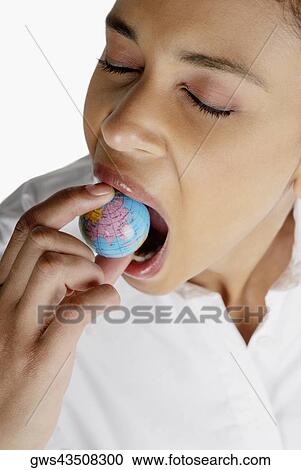 Close-up of a businesswoman holding a globe in her mouth View Large Photo Image Stock Image - Close-up of a businesswoman holding a globe in her mouth. Fotosearch