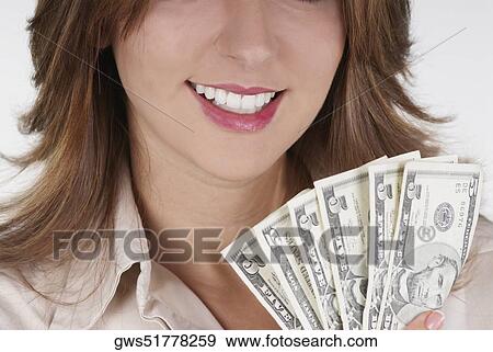 Close-up of a businesswoman holding fanned out dollar bills and smiling View Large Photo Image Stock Photo - Close-up of a businesswoman holding fanned out dollar bills and smiling. Fotosearch