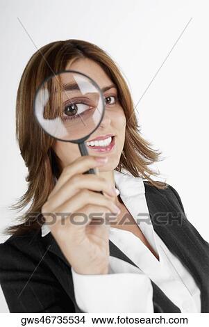 Close-up of a businesswoman looking through a magnifying glass View Large Photo Image Picture - Close-up of a businesswoman looking through a magnifying glass. Fotosearch