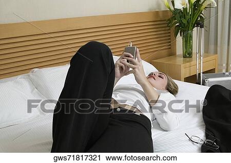 Close-up of a businesswoman lying on the bed listening to an MP3 player View Large Photo Image Stock Image - Close-up of a businesswoman lying on the bed listening to an MP3 player. Fotosearch