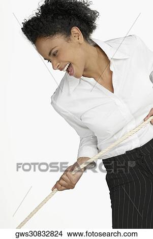 Close-up of a businesswoman pulling a rope and laughing View Large Photo Image Picture - Close-up of a businesswoman pulling a rope and laughing. Fotosearch