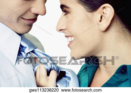 Stock Image - Close-up of a businesswoman pulling a businessman's tie. Fotosearch