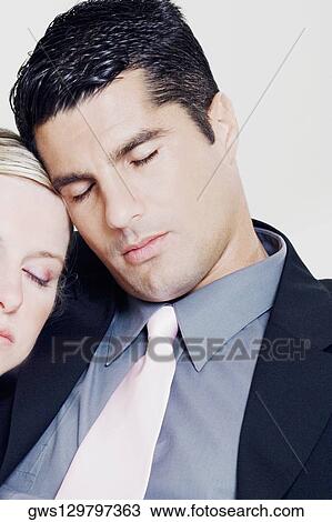 Stock Image - Close-up of a businesswoman resting her head on a businessman's shoulder. Fotosearch