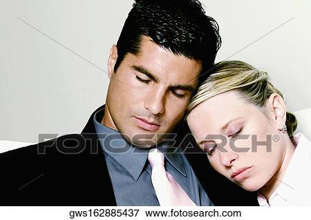 Close-up of a businesswoman resting her head on a businessman's shoulder View Large Photo Image Stock Photo - Close-up of a businesswoman resting her head on a businessman's shoulder. Fotosearch