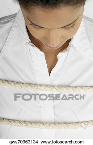 Picture - Close-up of a businesswoman tied up with a rope. Fotosearch
