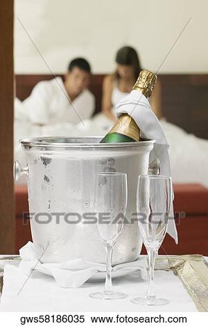 Close-up of a champagne bottle in an ice bucket with two champagne flutes View Large Photo Image Stock Photography - Close-up of a champagne bottle in an ice bucket with two champagne flutes. Fotosearch