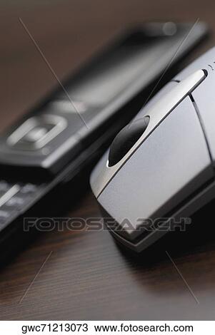 Stock Image - Close-up of a computer mouse with a mobile phone. Fotosearch