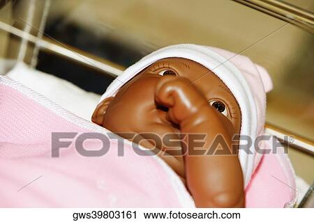 Stock Image - Close-up of a doll sucking its thumb. Fotosearch