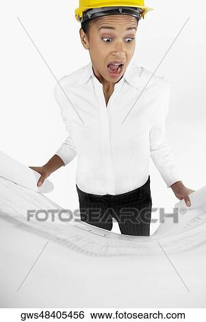 Close-up of a female architect holding a blueprint with her mouth open View Large Photo Image Stock Photograph - Close-up of a female architect holding a blueprint with her mouth open. Fotosearch