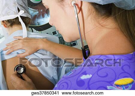 Close-up of a female doctor examining a female patient with a stethoscope View Large Photo Image Stock Image - Close-up of a female doctor examining a female patient with a stethoscope. Fotosearch