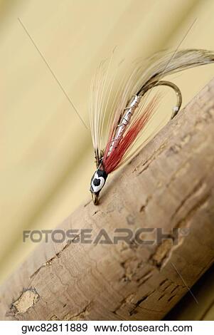 Stock Photo - Close-up of a fishing lure on a wooden post. Fotosearch