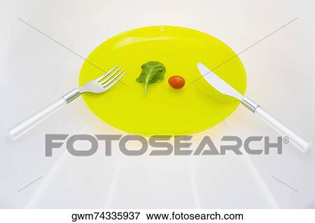 Close-up of a fork and a knife with a cherry tomato on a plate View Large Photo Image Stock Photo - Close-up of a fork and a knife with a cherry tomato on a plate. Fotosearch