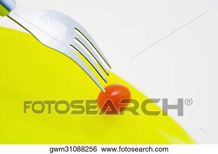 Close-up of a fork with a cherry tomato View Large Photo Image Stock Photograph - Close-up of a fork with a cherry tomato. Fotosearch