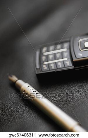 Stock Image - Close-up of a fountain pen near a mobile phone. Fotosearch