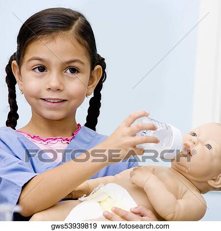 Close-up of a girl feeding a doll from a baby bottle View Large Photo Image Stock Photo - Close-up of a girl feeding a doll from a baby bottle. Fotosearch