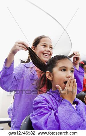 Close-up of a girl holding her sister's hair View Large Photo Image Stock Image - Close-up of a girl holding her sister's hair. Fotosearch