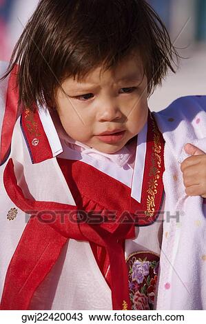 Stock Image - Close-up of a girl in traditional clothing thinking. Fotosearch