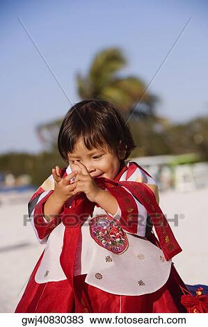 Close-up of a girl in traditional clothing looking at her hands View Large Photo Image Stock Image - Close-up of a girl in traditional clothing looking at her hands. Fotosearch