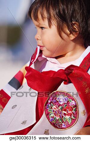 Stock Photography - Close-up of a girl in traditional clothing looking away. Fotosearch