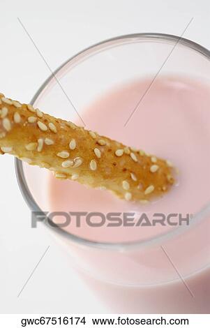 Picture - Close-up of a glass of milkshake with a breadstick. Fotosearch