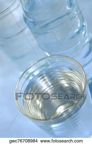 Close-up of a glass of water with two water bottles View Large Photo Image Picture - Close-up of a glass of water with two water bottles. Fotosearch