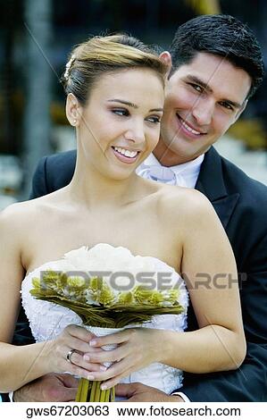 Close-up of a groom embracing his bride from behind View Large Photo Image Stock Image - Close-up of a groom embracing his bride from behind. Fotosearch