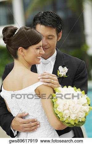 Close-up of a groom embracing his bride View Large Photo Image Stock Photo - Close-up of a groom embracing his bride. Fotosearch