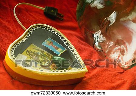Close-up of a heart shaped lamp with a glass statue on a sheet View Large Photo Image Stock Image - Close-up of a heart shaped lamp with a glass statue on a sheet. Fotosearch