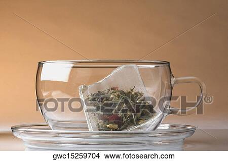 Picture - Close-up of a herbal teabag in a cup. Fotosearch