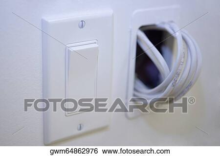 Close-up of a light switch with a roll of cable coming out from a wall View Large Photo Image Stock Photograph - Close-up of a light switch with a roll of cable coming out from a wall. Fotosearch