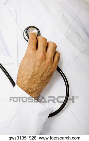 Close-up of a male doctor examining himself with a stethoscope View Large Photo Image Stock Photo - Close-up of a male doctor examining himself with a stethoscope. Fotosearch