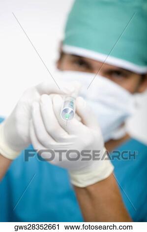 Close-up of a male doctor holding a syringe View Large Photo Image Stock Image - Close-up of a male doctor holding a syringe. Fotosearch
