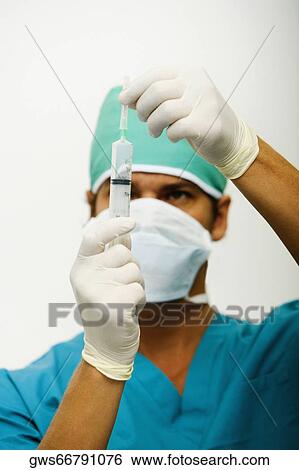 Close-up of a male surgeon holding a syringe View Large Photo Image Stock Photograph - Close-up of a male surgeon holding a syringe. Fotosearch