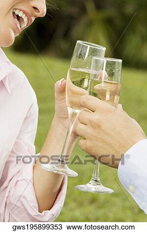 Close-up of a man and a woman toasting with champagne flutes View Large Photo Image Stock Image - Close-up of a man and a woman toasting with champagne flutes. Fotosearch
