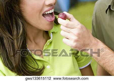 Close-up of a man feeding a young woman a plum View Large Photo Image Stock Image - Close-up of a man feeding a young woman a plum. Fotosearch