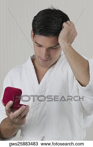 Close-up of a man looking at a jewelry box View Large Photo Image Stock Image - Close-up of a man looking at a jewelry box. Fotosearch