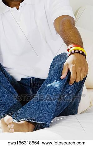 Close-up of a man sitting on the bed View Large Photo Image Picture - Close-up of a man sitting on the bed. Fotosearch