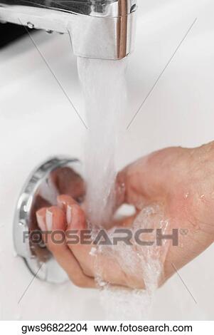 Close-up of a man washing his hands in the bathroom sink View Large Photo Image Picture - Close-up of a man washing his hands in the bathroom sink. Fotosearch