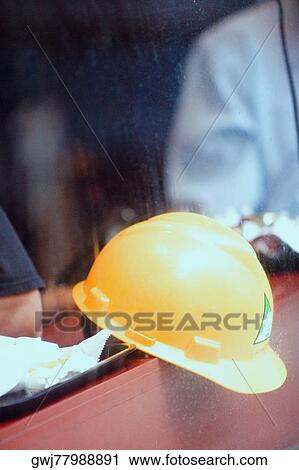 Stock Image - Close-up of a man's hand holding a hardhat. Fotosearch