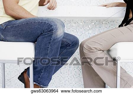 Close-up of a man's legs and a woman sitting on a stool View Large Photo Image Picture - Close-up of a man's legs and a woman sitting on a stool. Fotosearch