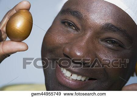 Close-up of a mature man holding a golden egg View Large Photo Image Stock Photo - Close-up of a mature man holding a golden egg. Fotosearch