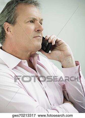 Stock Photo - Close-up of a mature man holding a mobile phone. Fotosearch