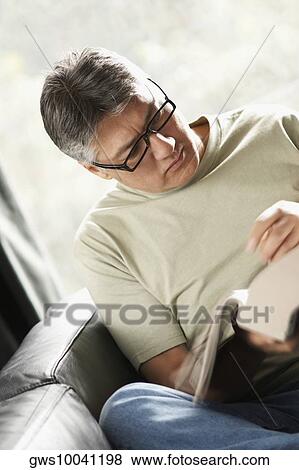 Close-up of a mature man reading a book View Large Photo Image Stock Photo - Close-up of a mature man reading a book. Fotosearch