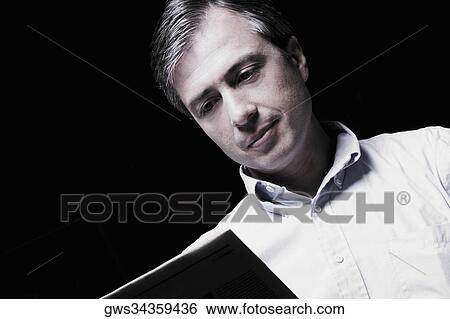 Close-up of a mature man reading a book View Large Photo Image Stock Photograph - Close-up of a mature man reading a book. Fotosearch