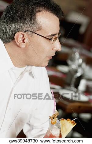 Stock Image - Close-up of a mature man sitting in a restaurant. Fotosearch