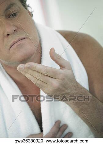 Stock Image - Close-up of a mature man touching his face. Fotosearch