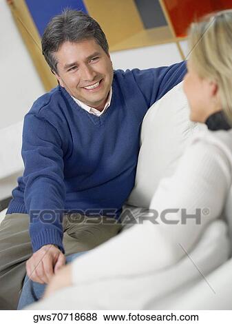 Close-up of a mature man with a mid adult woman sitting on a couch and looking at each other View Large Photo Image Stock Photo - Close-up of a mature man with a mid adult woman sitting on a couch and looking at each other. Fotosearch
