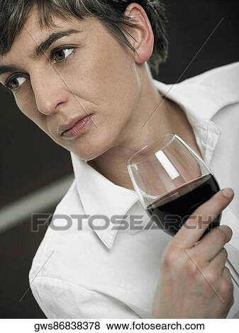 Stock Photo - Close-up of a mature woman holding a glass of red wine. Fotosearch