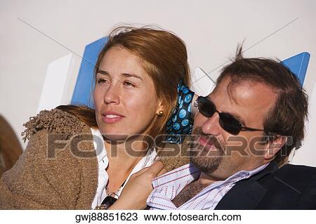 Close-up of a mid adult couple reclining on a lounge chair View Large Photo Image Stock Image - Close-up of a mid adult couple reclining on a lounge chair. Fotosearch