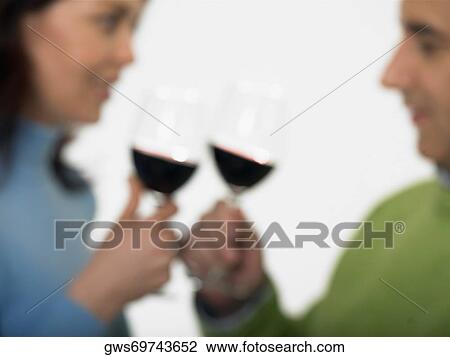 Stock Image - Close-up of a mid adult couple toasting glasses of wine. Fotosearch